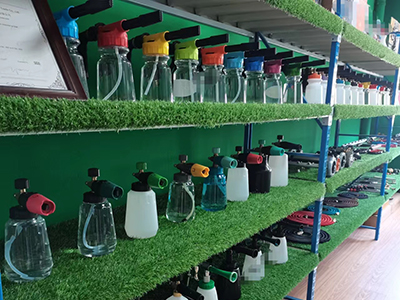 an assortment of plastic and metal car wash nozzles and foam cannons on a workshop bench