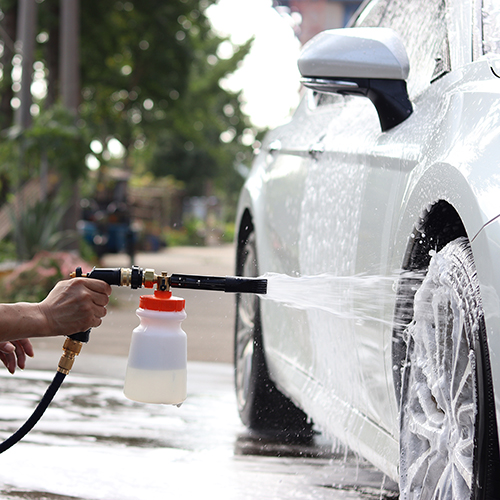 A car being covered in thick, luxurious foam from the garden hose foam cannon