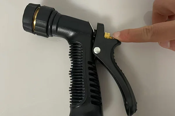 A close-up of the tension adjustment knob on the back of a foam gun handle