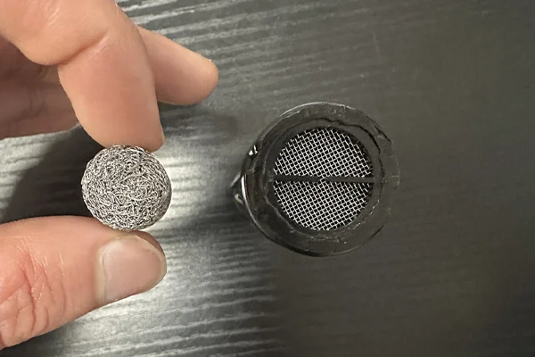 A comparison image showing a dense mesh filter from a foam cannon next to the simpler mesh screen from a foam gun