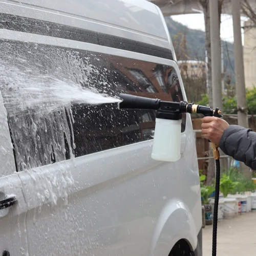 A new foam gun attached to a garden hose, creating thick foam on a car
