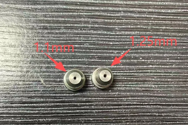 A side-by-side comparison of a 1.1mm and 1.25mm orifice